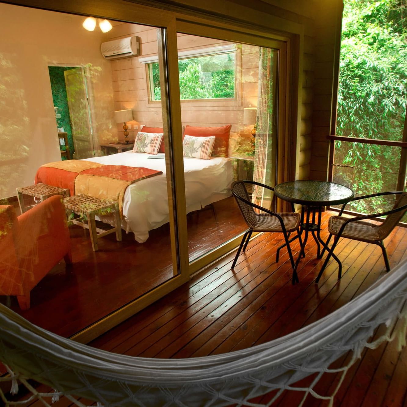 Jungle room balcony with a hammock and dining at DOT Hotels