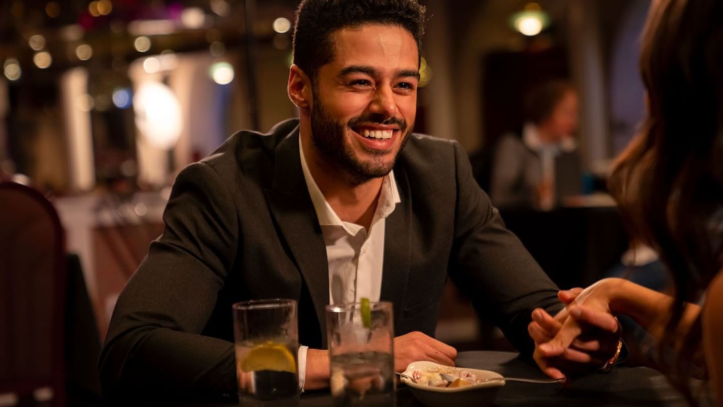 Man smiling at his partner across the table while holding her hand in The Restaurant at Cove Pocono Resorts