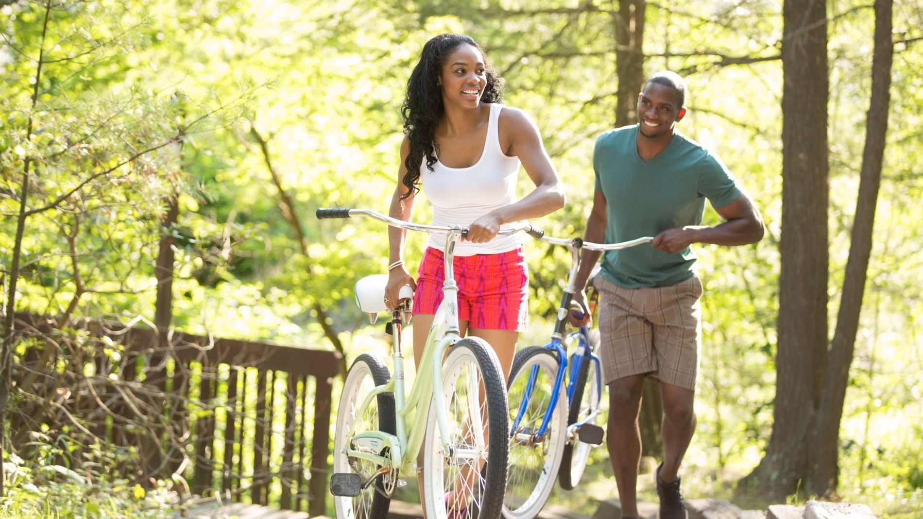 Couple with their bicycles on a trail, while exploring the surrounding near Cove Pocono Resorts