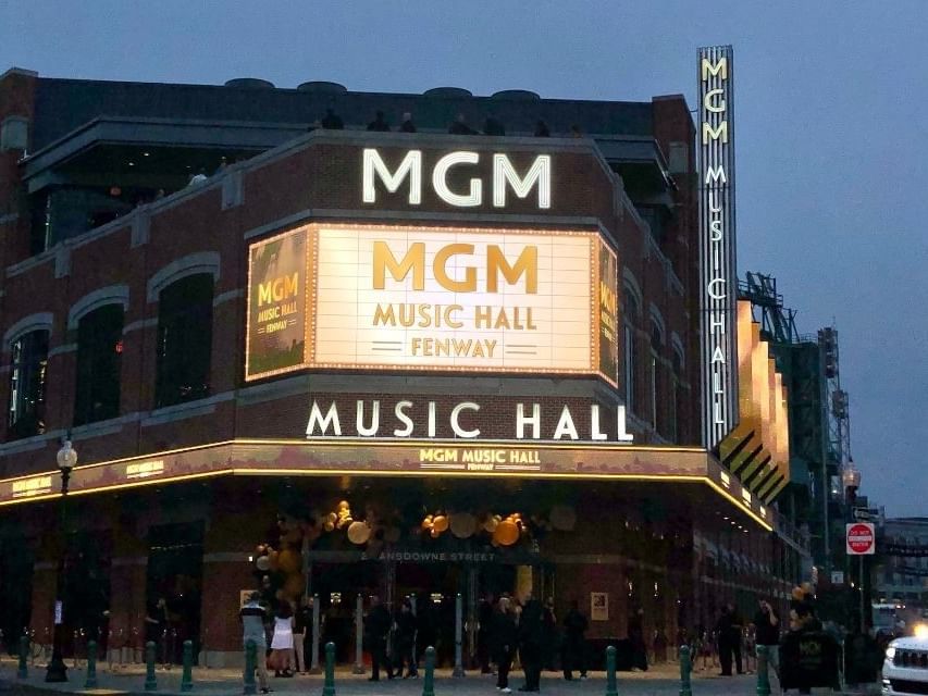 Exterior of the MGM Music Hall at Fenway at dusk with people milling about.