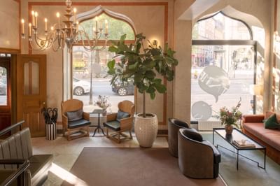 Lobby lounge area with a chandelier & street view at The Sparrow Hotel