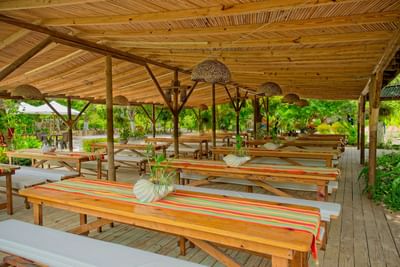 Dining area in La Mar restaurant with tables and chairs under a covered canopy at Hotel Isla Del Encanto