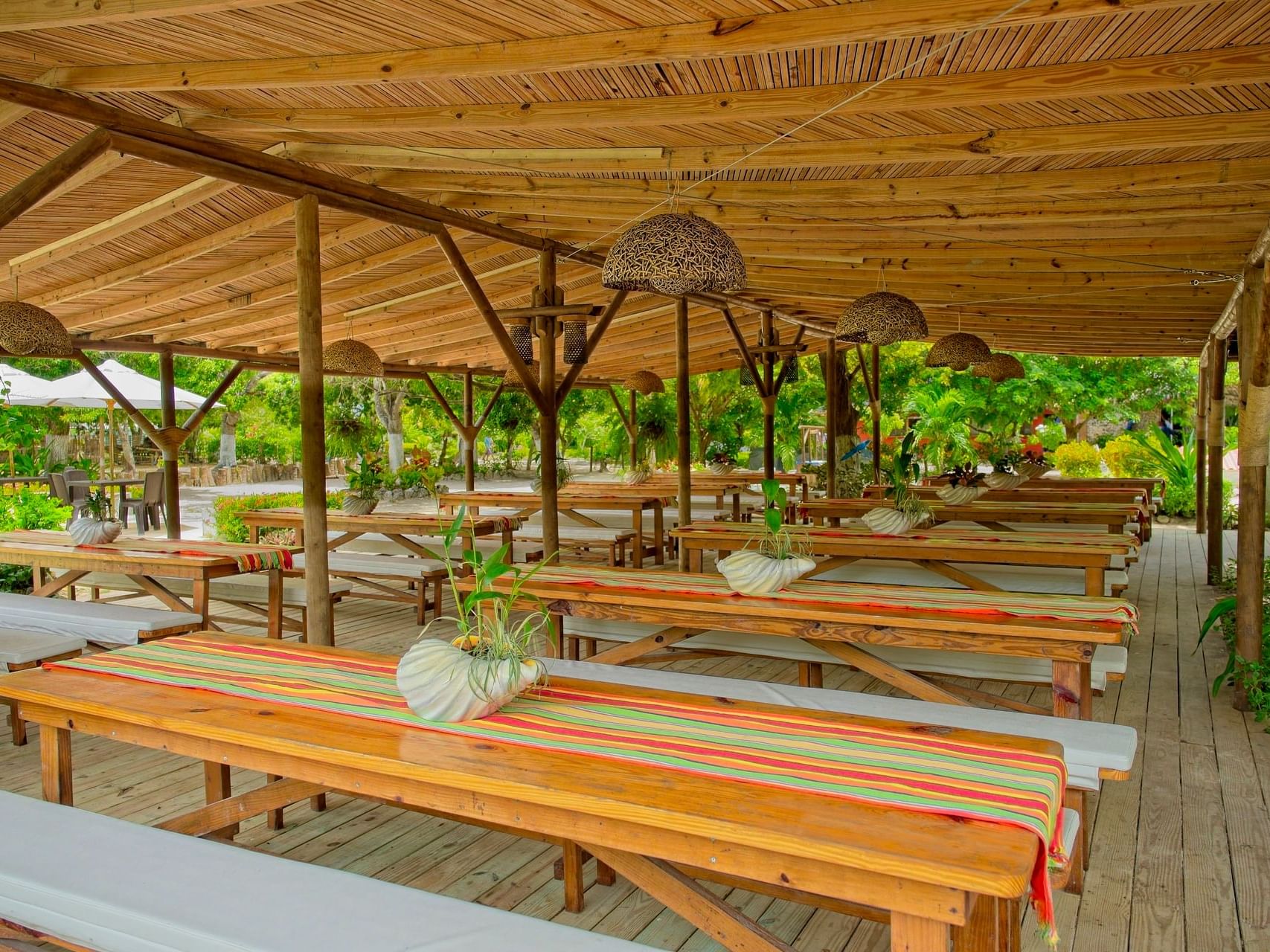 Dining area in La Mar restaurant with tables and chairs under a covered canopy at Hotel Isla Del Encanto
