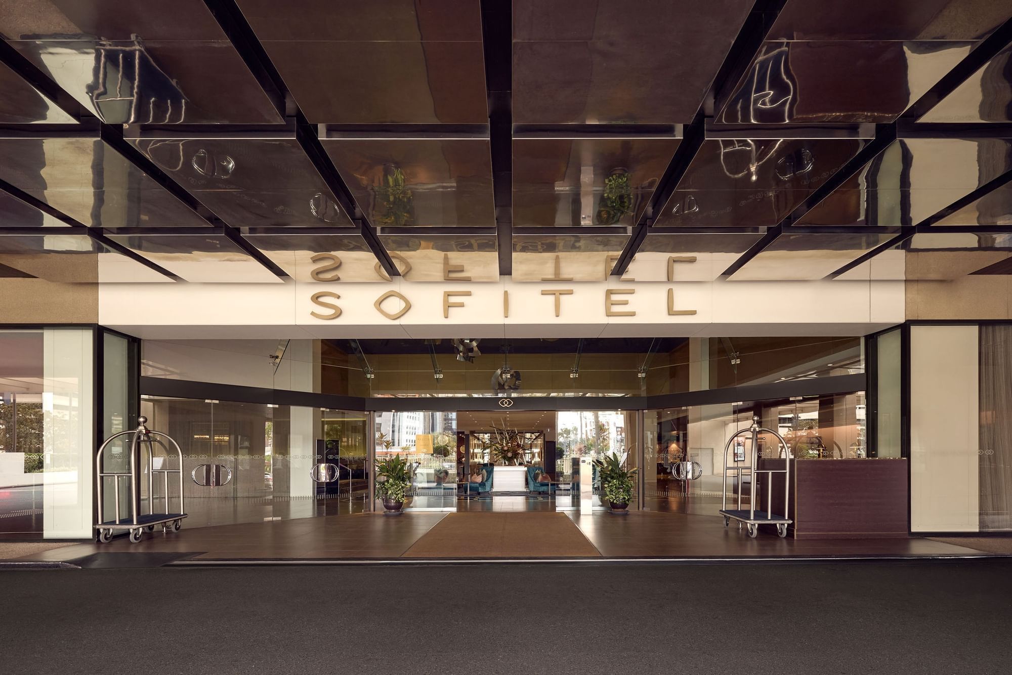 Exterior view of the entrance to the Sofitel hotel with mirrored ceiling and luggage cart