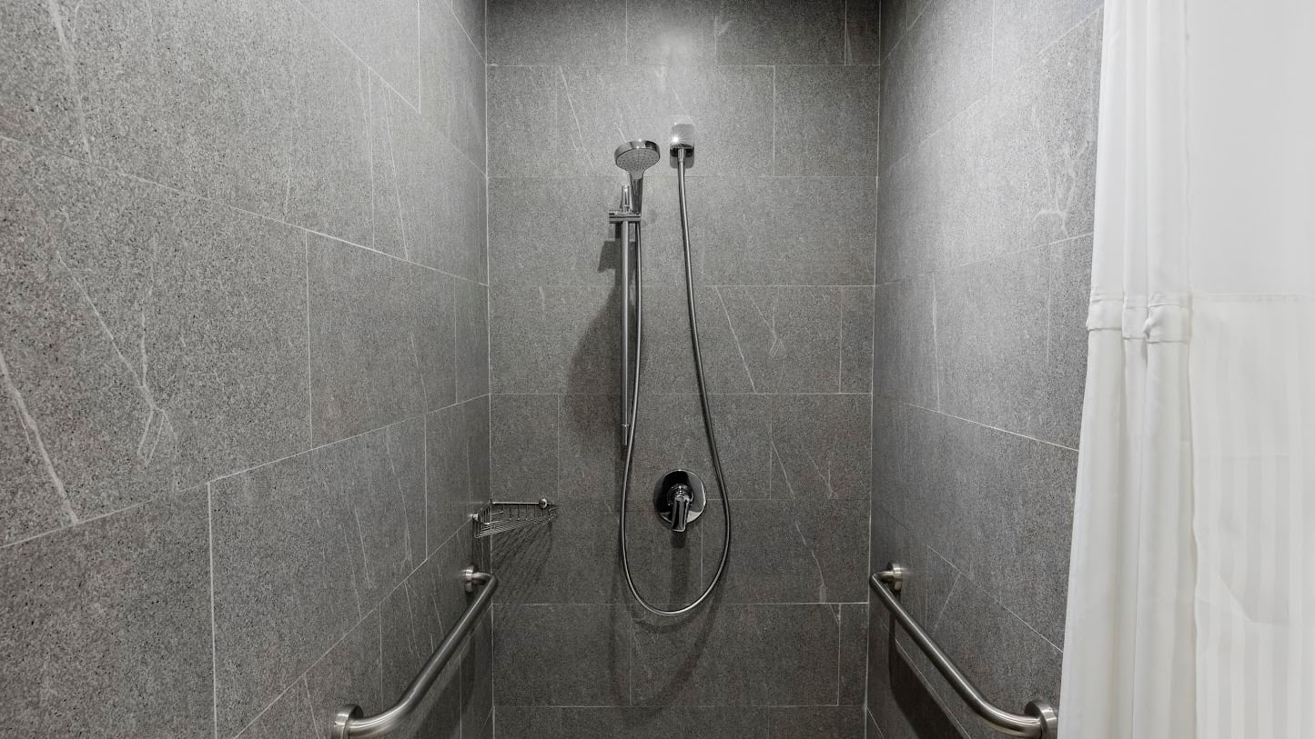 Accessible shower with chrome grab bars on tiled walls in room at Fiesta Inn Express Cancun Cumbres, accommodations in cancun
