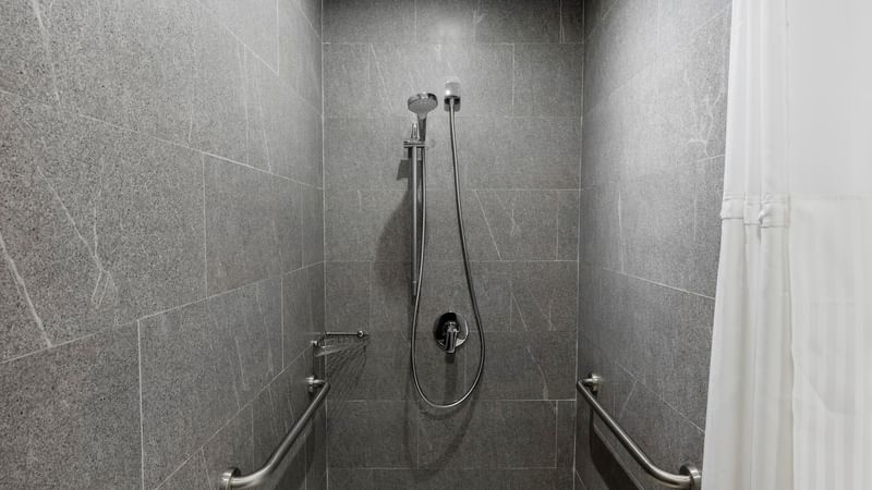 Accessible shower with chrome grab bars on tiled walls in room at Fiesta Inn Express Cancun Cumbres, accommodations in cancun