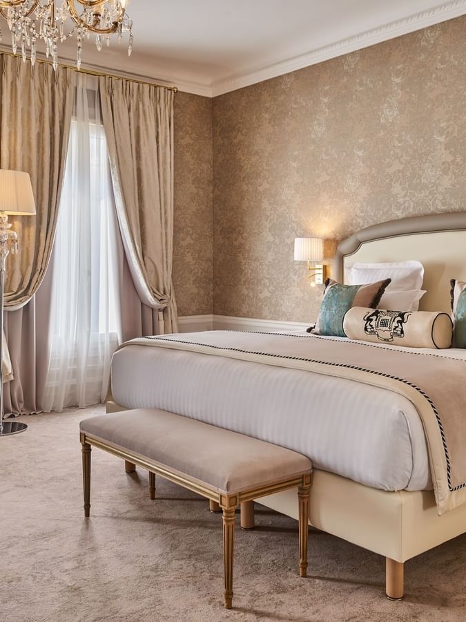 Bed with ottoman and couch near the window in Prestige Suite at Hotel Westminster Paris