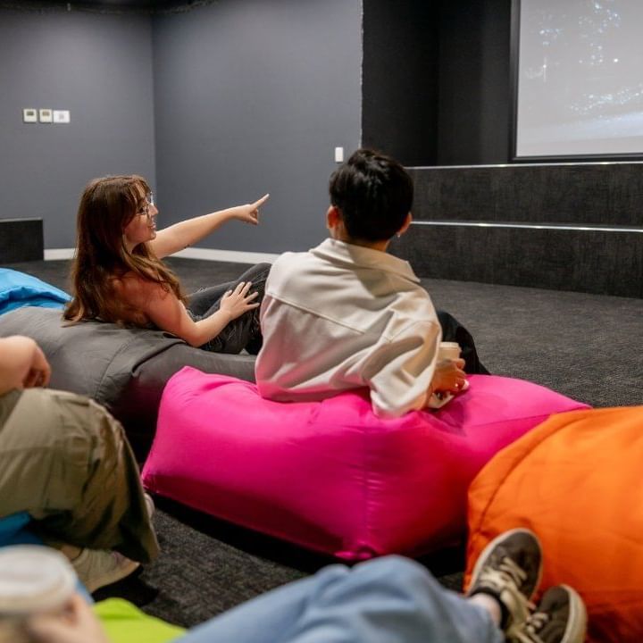 People watching a movie on beanbag chairs in a cinema room at UniLodge Victoria University.