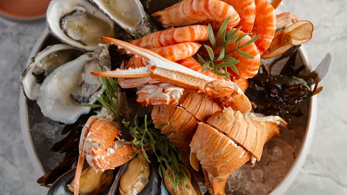 Platter of seafood including shrimp, oysters, and shellfish on ice served in Woodcut at Crown Towers Sydney