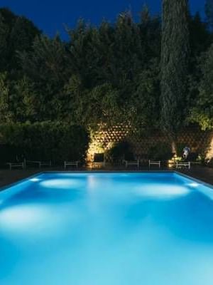 Swimming pool with loungers by night at Oceania Hotels Group