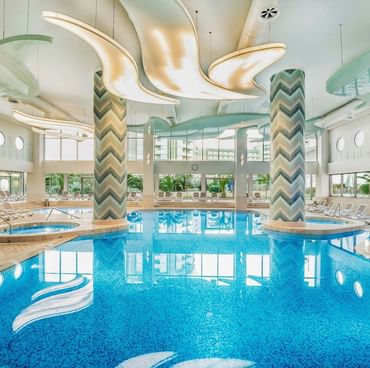 Элегантный интерьер крытого бассейна с мраморной отделкой в отеле Titanic Deluxe Lara.