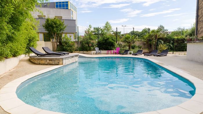 Pool view with trees and sun loungers at Le Clos des Tanneurs