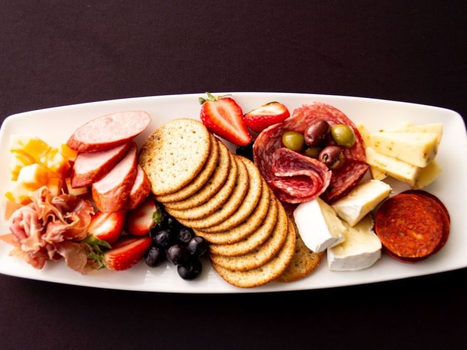 Charcuterie platter with a variety of meat, cheese & fruit served at Retro Suites Hotel