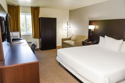 Work desk with TV facing the bed and seating in Accessible Executive King at Lake Natoma Inn