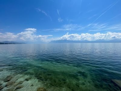 Lake Geneva under a blue sky with light clouds near Starling Hotel Lausanne