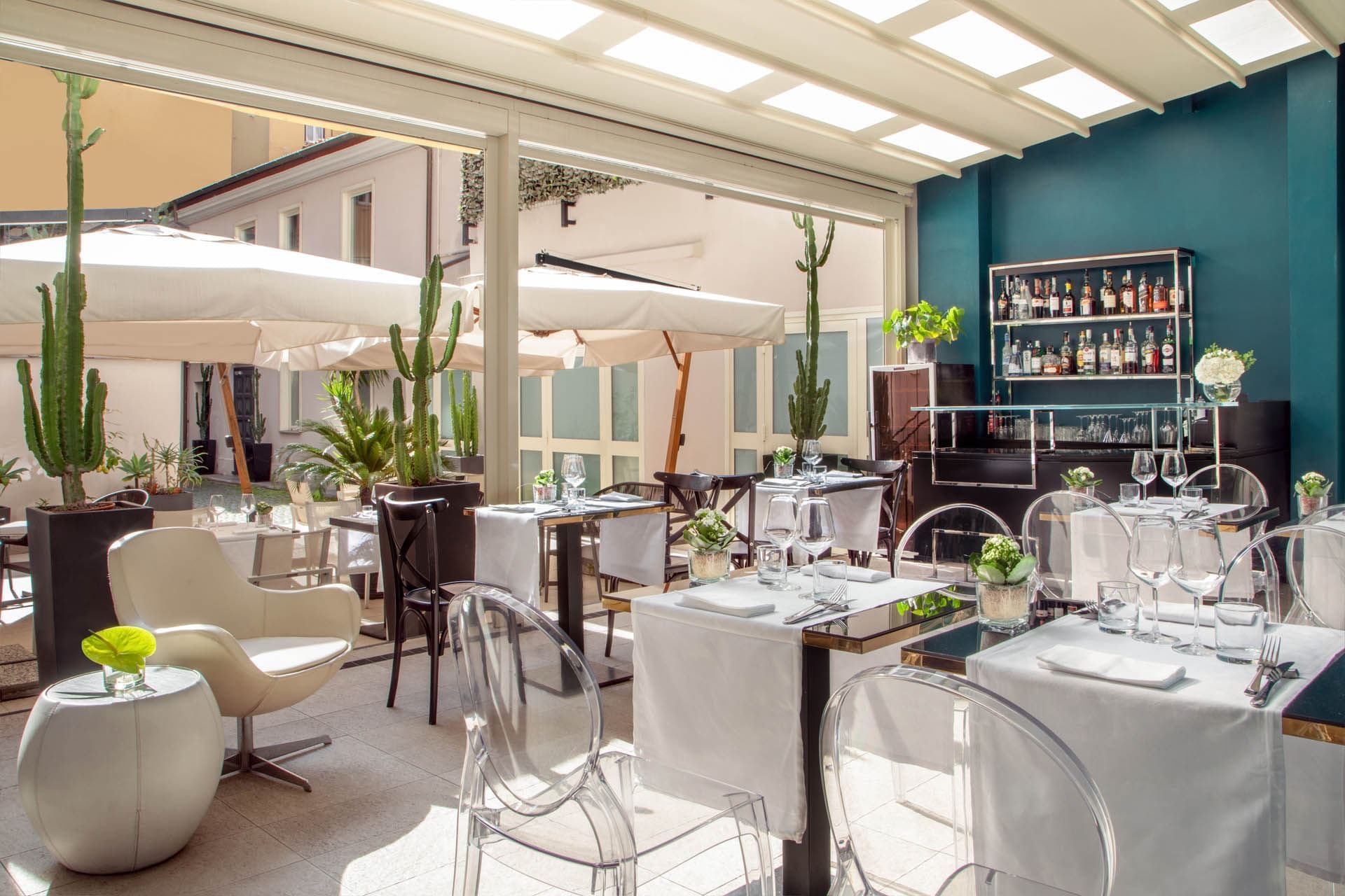 Bright and airy, The Guardian Dehors at The Guardian Hotel with elegant tables, a stocked bar, and a relaxing ambiance