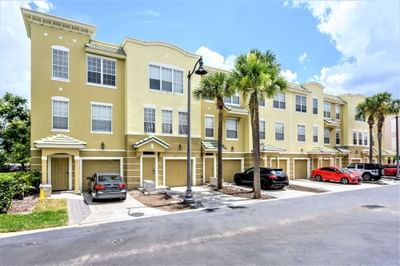 Townhome apartments building with cars parked at Vista Cay Resort By Millenium