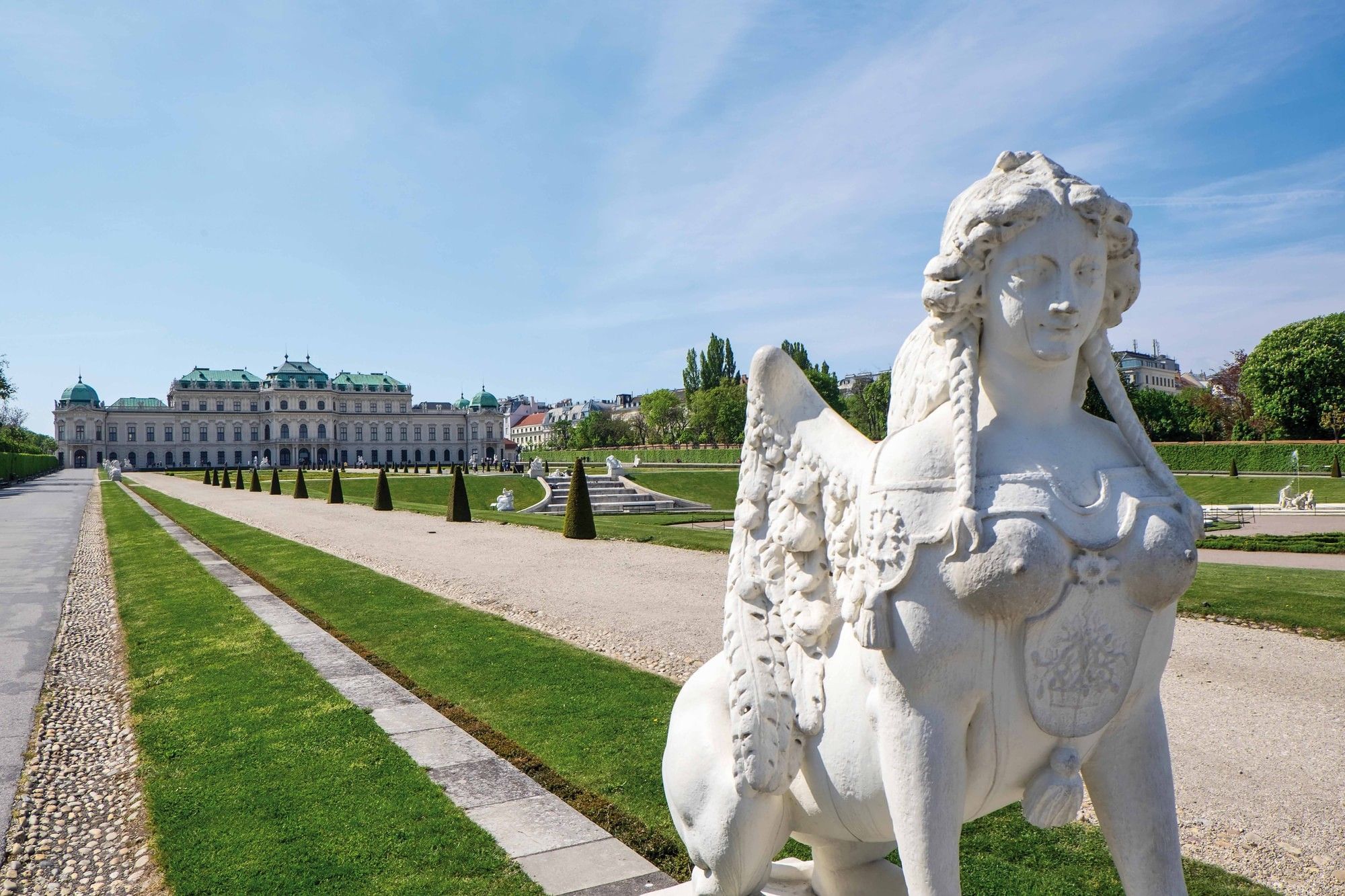 Schloss Belvedere in Wien mit barockem Garten und historischer Sphinx Skulptur im Vordergrund