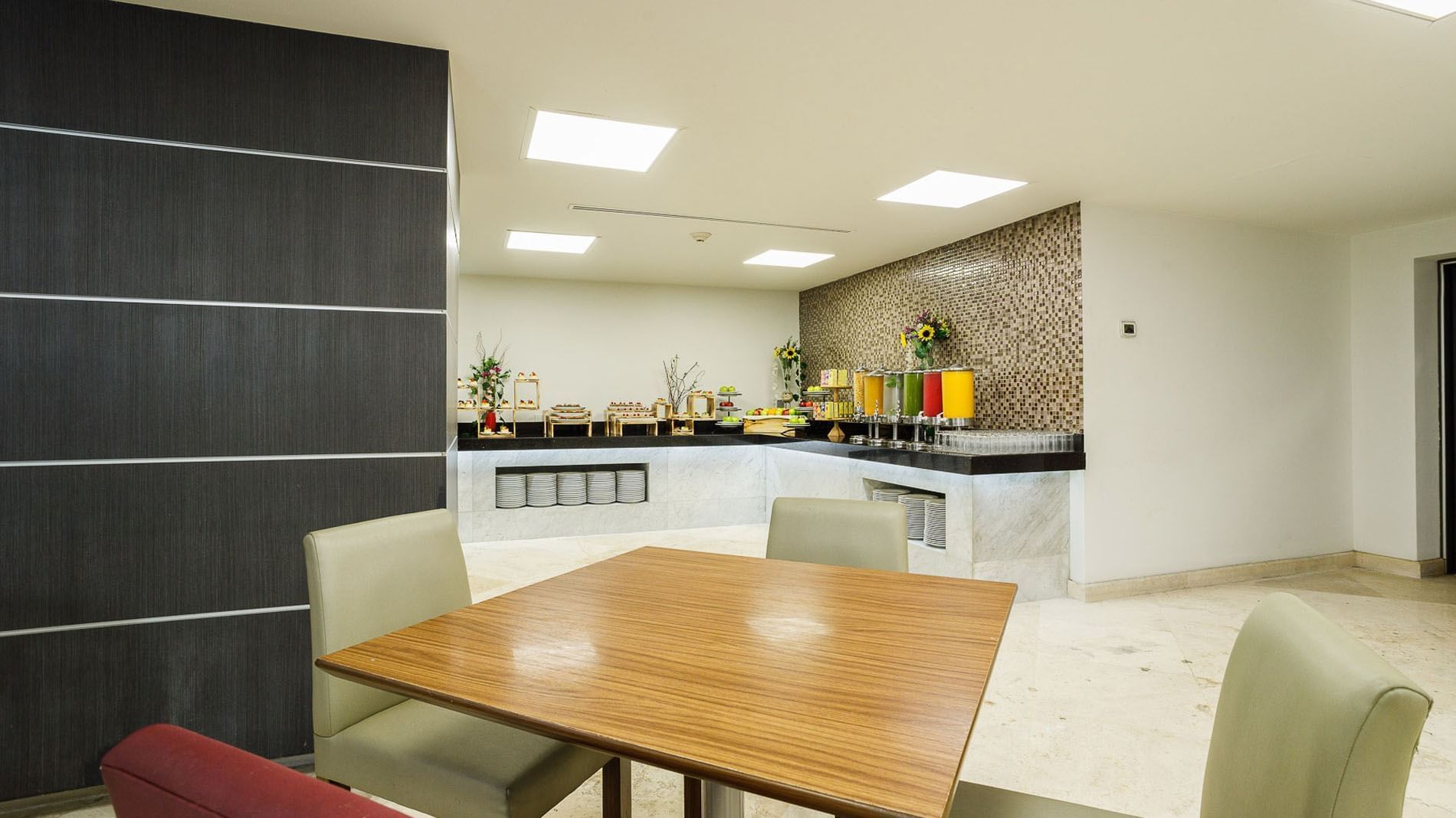 Stock Café breakfast buffet area with colorful juice dispensers and dining place at Real Inn Tijuana