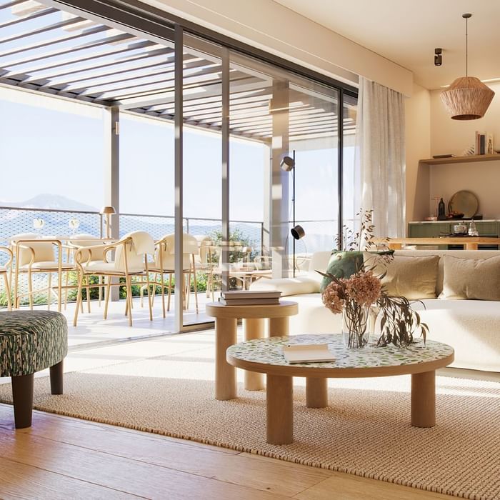 Bright living room with large sliding glass doors leading to a patio at Falkensteiner Hotels