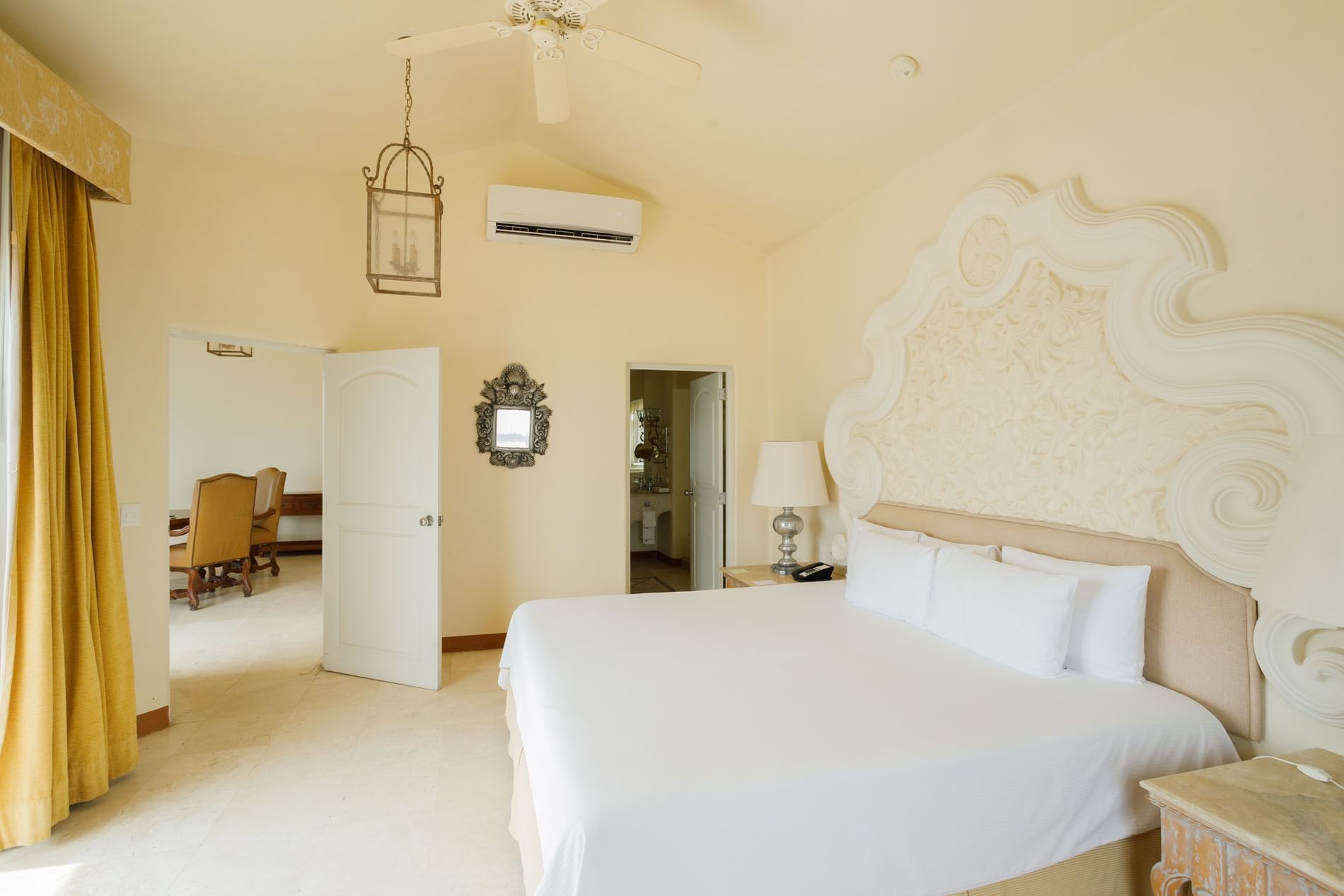 Luxurious bedroom suite with a large ornate headboard and bright, airy coastal decor at Quinta Real Acapulco