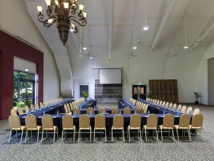 Large conference room with a U-shaped table by tan chairs under a ceiling in Farea Pacifik at Warwick Hotels & Resort