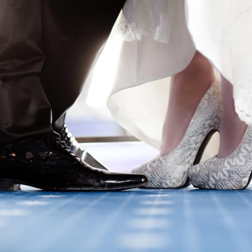 Bride and groom about to step on each others shoes, a traditional custom at Turkish weddings