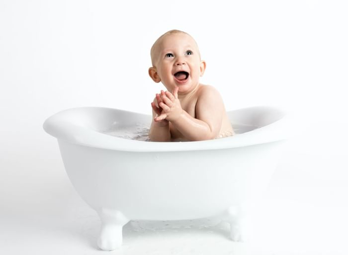 Smiling baby in a bath tub at Duparc Contemporary Suites