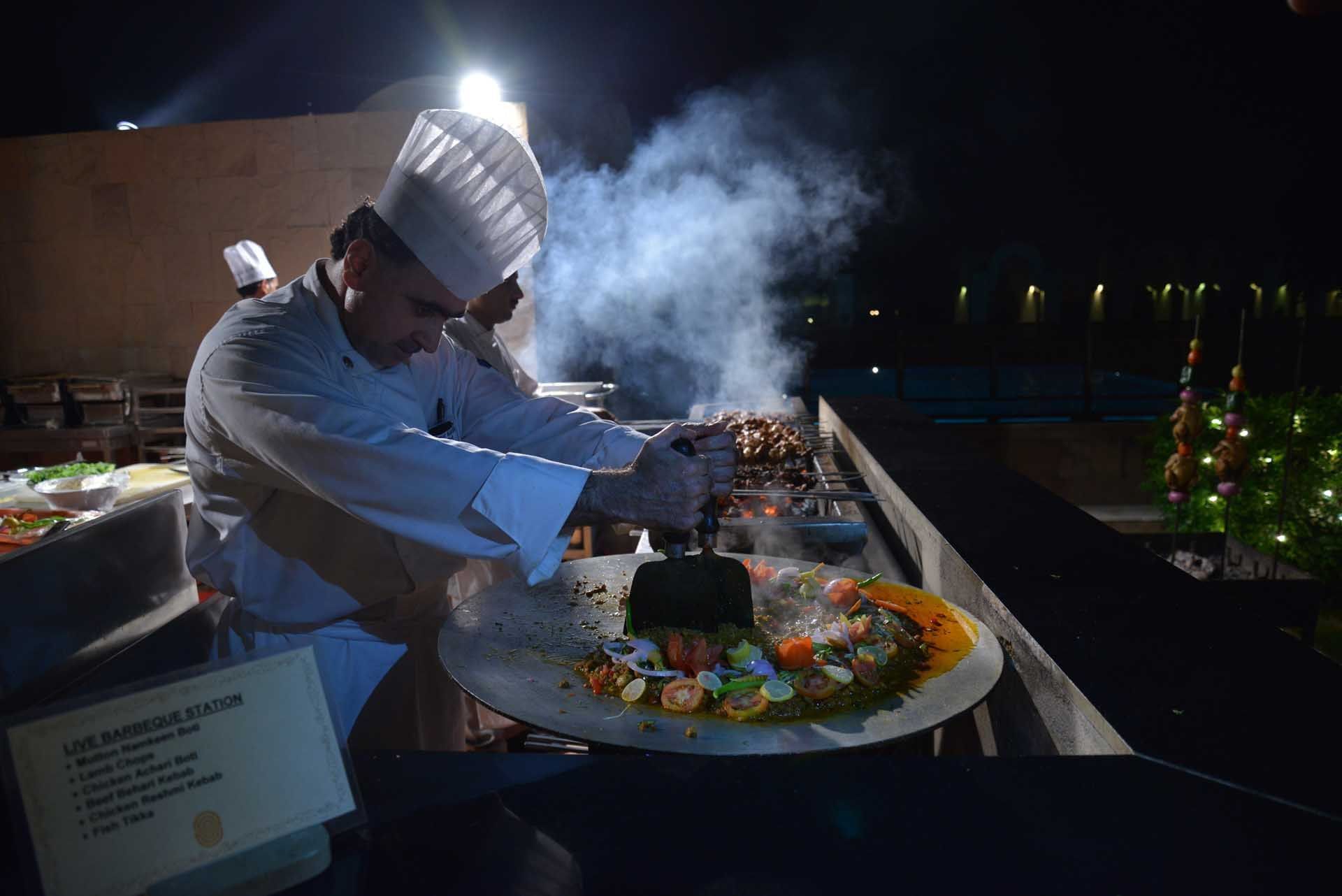 Chef cooking in open air at night in Islamabad Serena Hotel