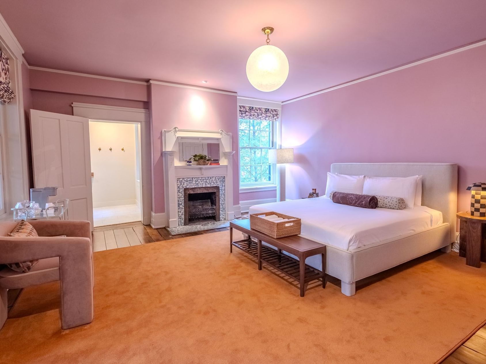 Seating area and fireplace by the bed in Grand King Suite at The Ashbrook Hotel, featuring Frankfort Kentucky lodging.