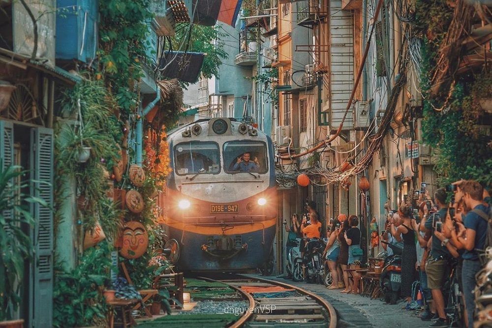 Crowd taking photos of a train passing through the railway near Sunway Hotel Hanoi