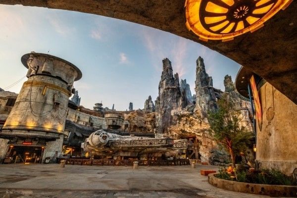 A rocky, rustic outcropping with glowing lights and a large spaceship at Star Wars Galaxy's Edge at Hollywood Studios.