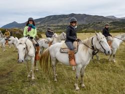 People horseback riding in Patagonia near Hoteles Australis