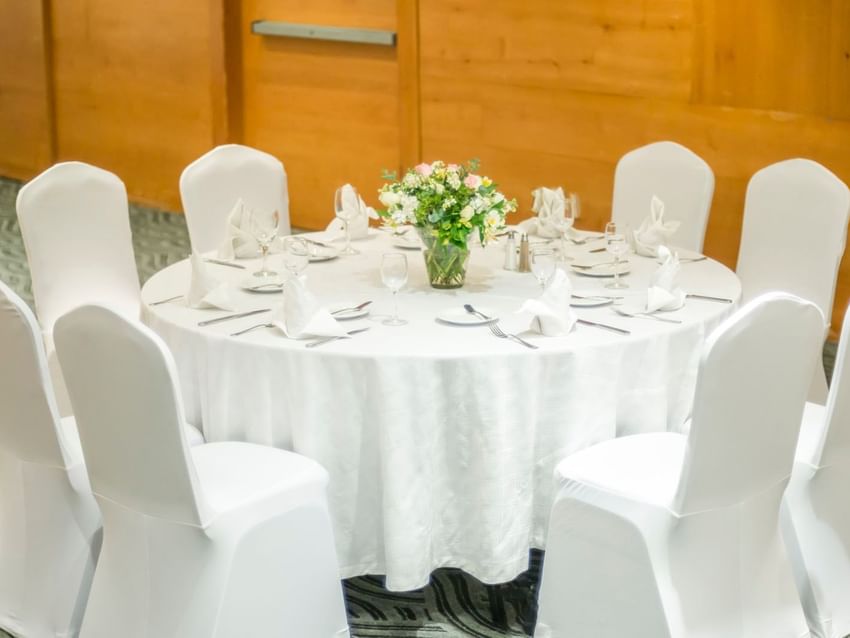 Close-up of banquet table in Buenos Aires Venue featuring white linens and a fresh floral centerpiece at Real Inn Perinorte