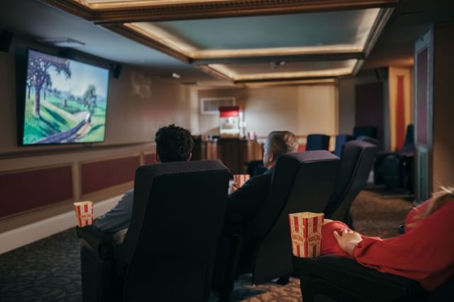 Guests seated in theater chairs watching movie screen with popcorn containers at Mountain View Grand Resort & Spa