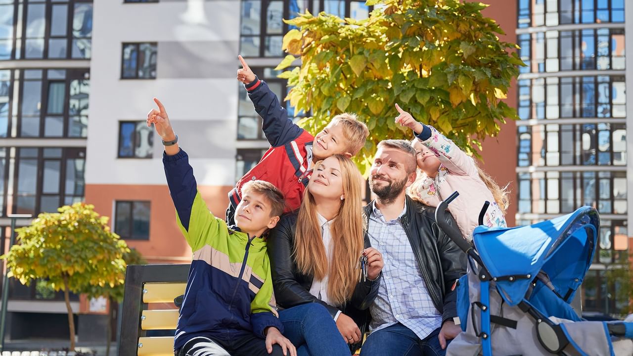 family of five sitting and pointing in the air