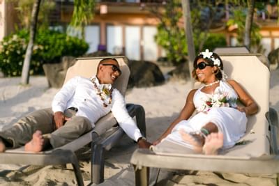 A wedded couple lounging by the beach at True Blue Bay Hotel
