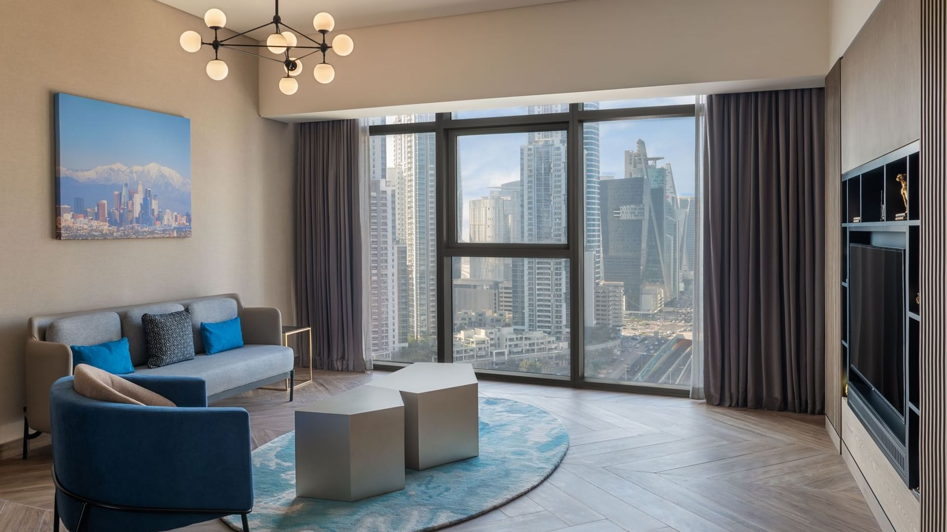 Stylish living room with comfortable seating and expansive city views from large windows at Paramount Hotel Midtown