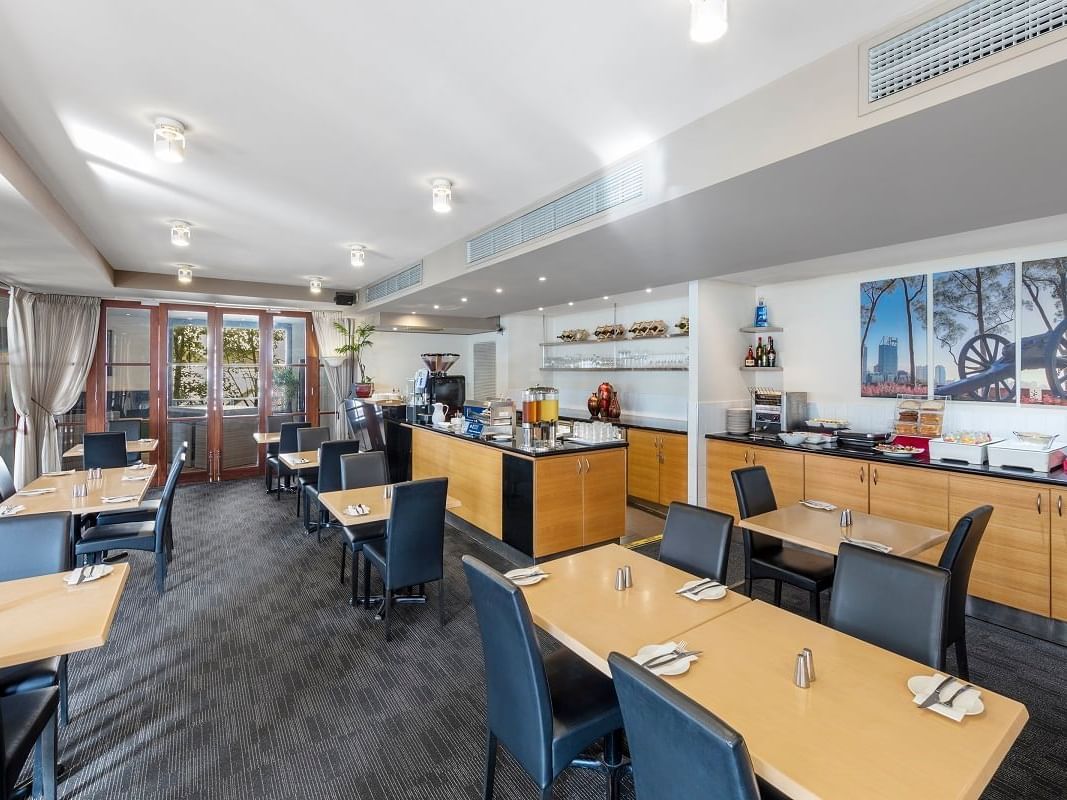 Dining tables arranged in the Courtside Restaurant at Nesuto Mounts Bay Perth Apartment Hotel
