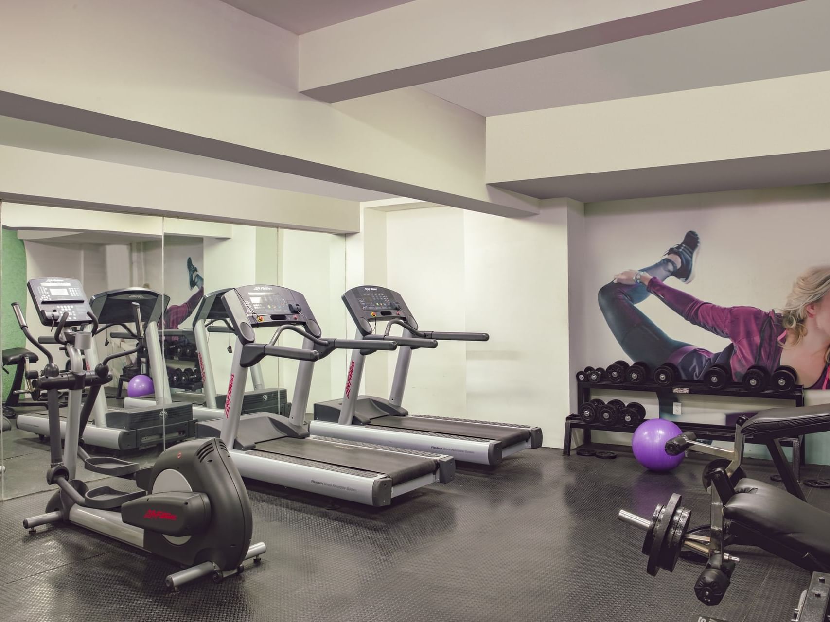 Interior of the gym with fitness machines at Gamma Hotels