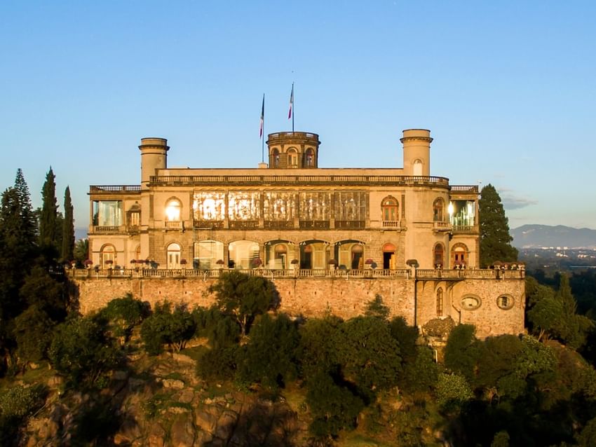 Castillo de piedra en una colina rodeado de árboles verdes cerca de Camino Real Hotels