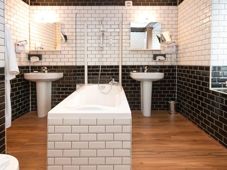 Salle de bains avec baignoire et deux lavabos dans la Junior suite à Hôtel Villa Aultia, Ault.