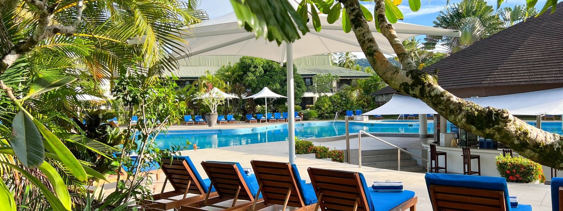 Lounge chairs by the swimming pool at The Naviti Resort in Korolevu
