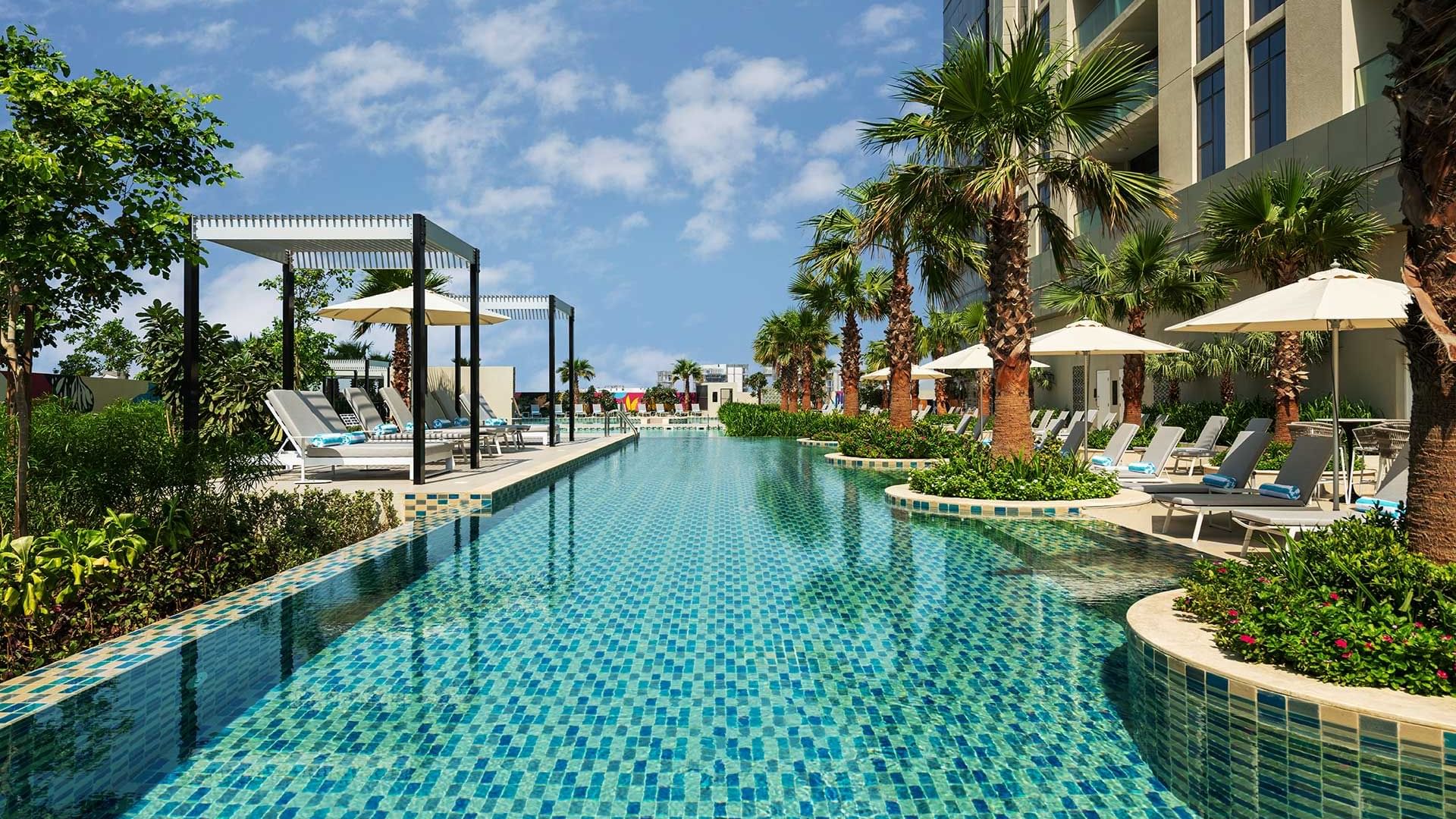 Outdoor pool with sunbeds at Dubai Pool Hotel by DAMAC Maison Aykon City