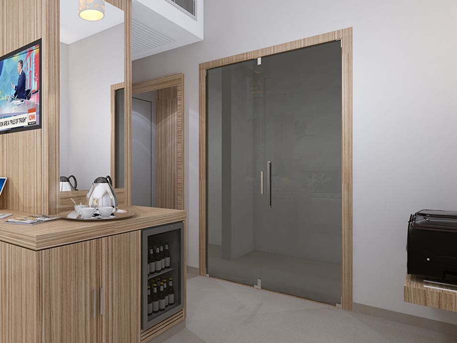 Office pantry with a kettle, built-in wine cooler, and frosted glass door at Azalai Hotel Ouagadougou