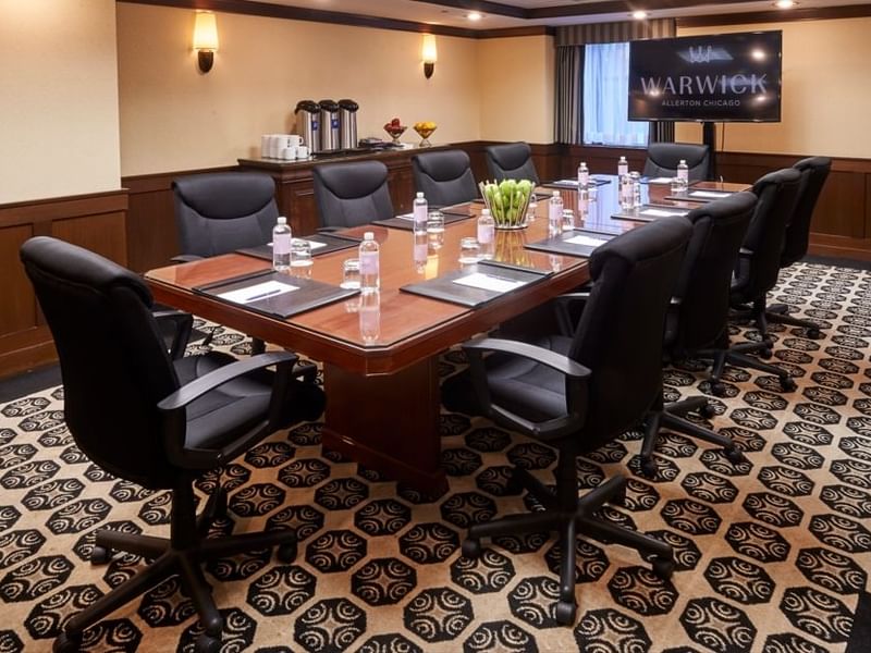 Solid Boardroom with large wooden table with black chairs at Warwick Allerton - Chicago