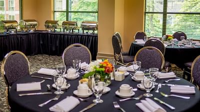 Elegant buffet setup and round dining table for an event in Michiko Room at Rosedale on Robson Suite Hotel