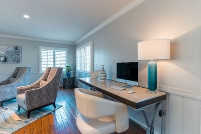 A chic desk area with a computer, stylish white and blue decor, and two patterned armchairs at Carmel Bay View Inn