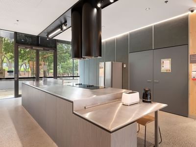 Modern kitchen area with stainless steel countertops and appliances at La Trobe University apartments.