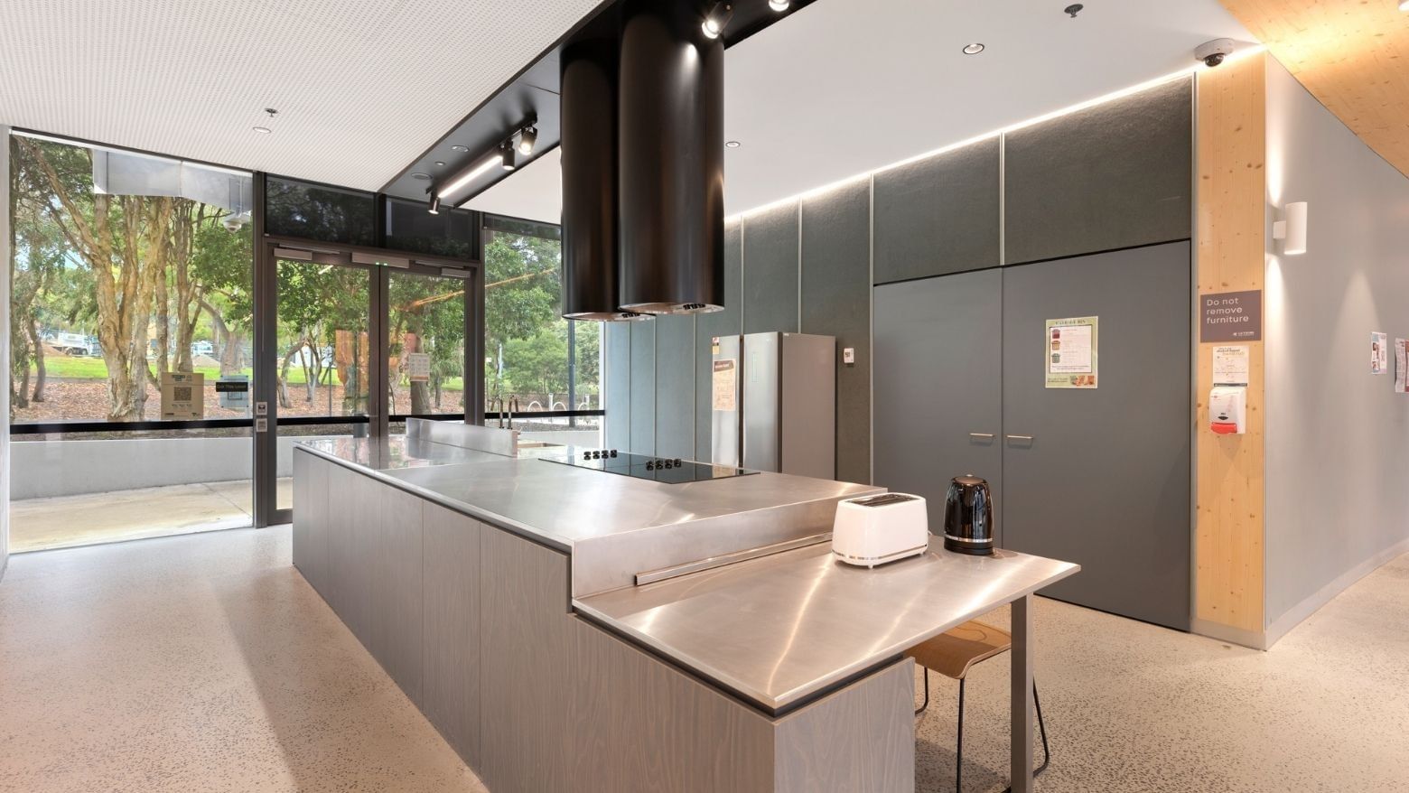 Modern kitchen area with stainless steel countertops and appliances at La Trobe University apartments.